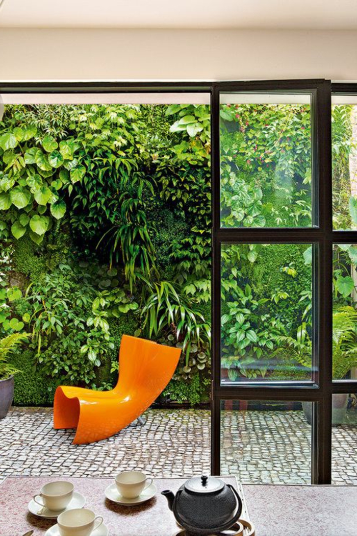 terrassenboden-aus-stein-orange-stuhl-gläserne-wände