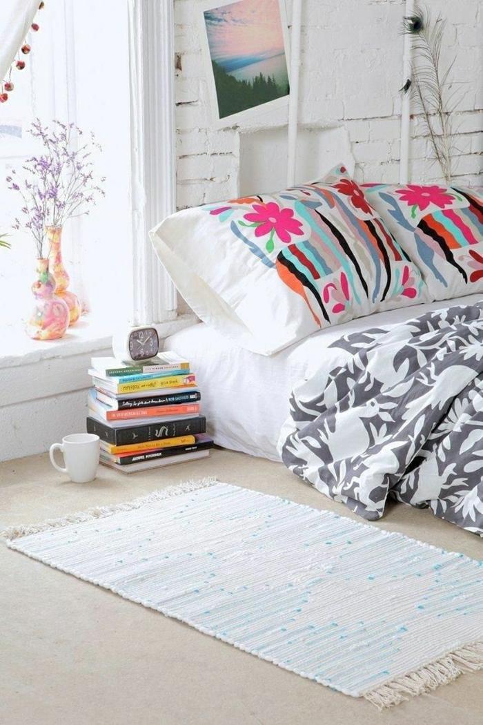 weißes-Schlafzimmer-Ziegelwände-Bild-Vasen-Kaffeetasse-Bücher-Kissen-lustige-Muster-Bettwäsche-grau-weiß-Tieren-Muster