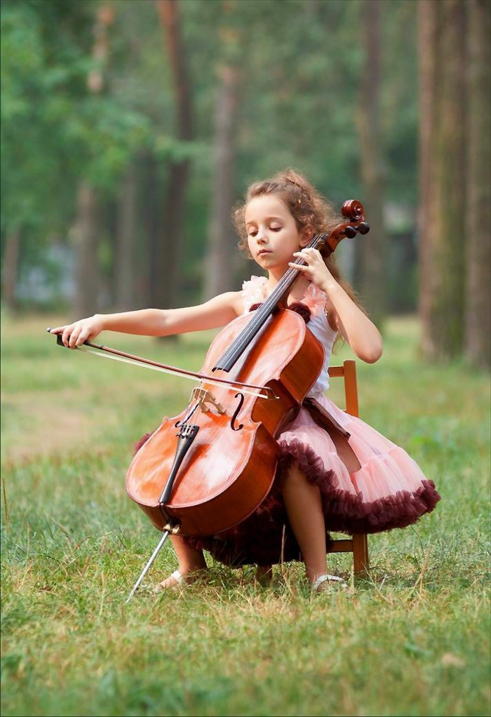 Natur-Gras-kleines-Mädchen-Cello-spielend