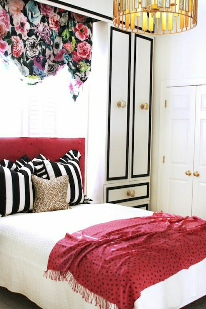 Schlafzimmer-schwarz-weiße-Kissen-Schrank-rote-Schlafdecke-bunte-Gardinen-Blumen-Muster