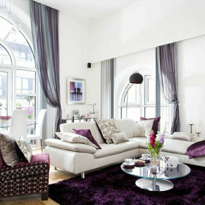 Wohnzimmer-beige-Sofa-Kissen-Teppich-Sessel-lila-Plüsch-Gardinen-Tüll-lila-blau