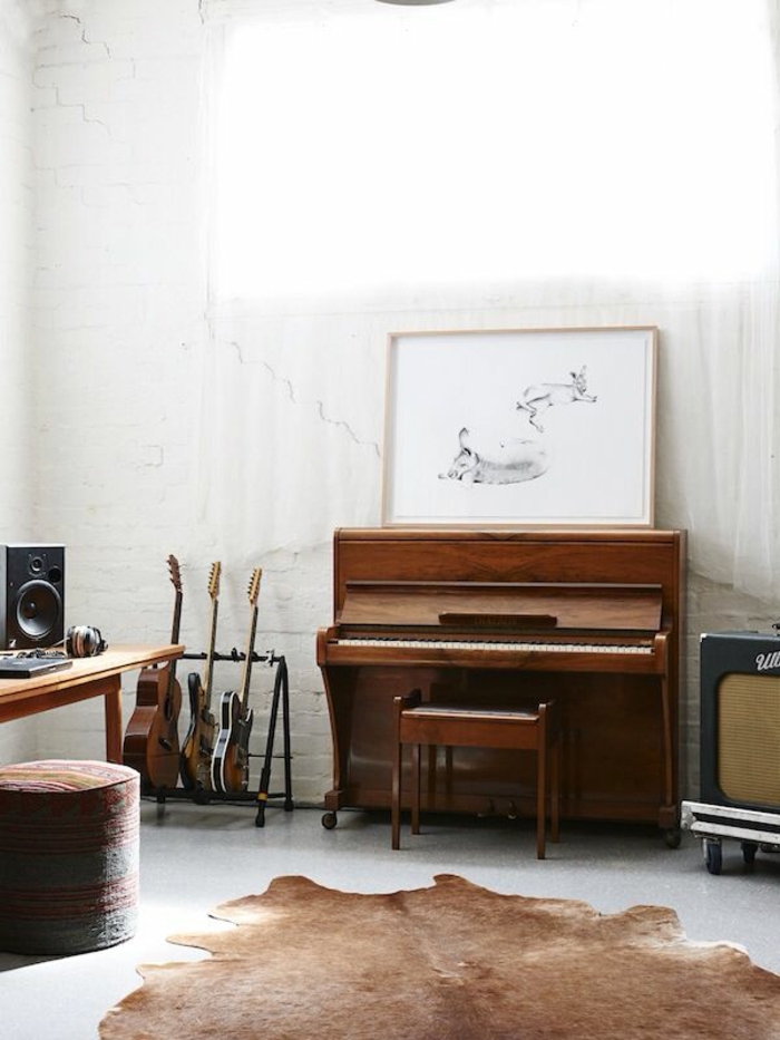 Zimmer-rustikale-Gestaltung-weiße-Ziegelwände-vintage-Klavier-Gitarren-Bild-Hocker-Tierhaut