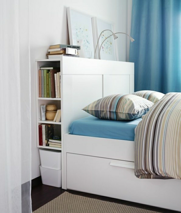 elegantes-Schlafzimmer-weißes-Bett-mit-Schubladen-Bücher-Bilder