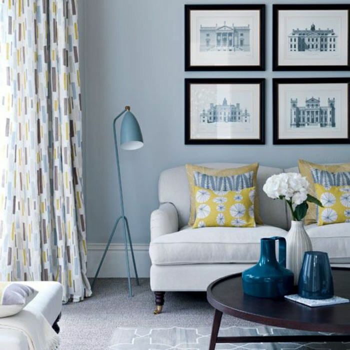 gemütliches-Wohnzimmer-stilvolle-Gestaltung-Bilder-Sofa-industrielle-Stehlampe-Gardinen-blau-grau-gelb
