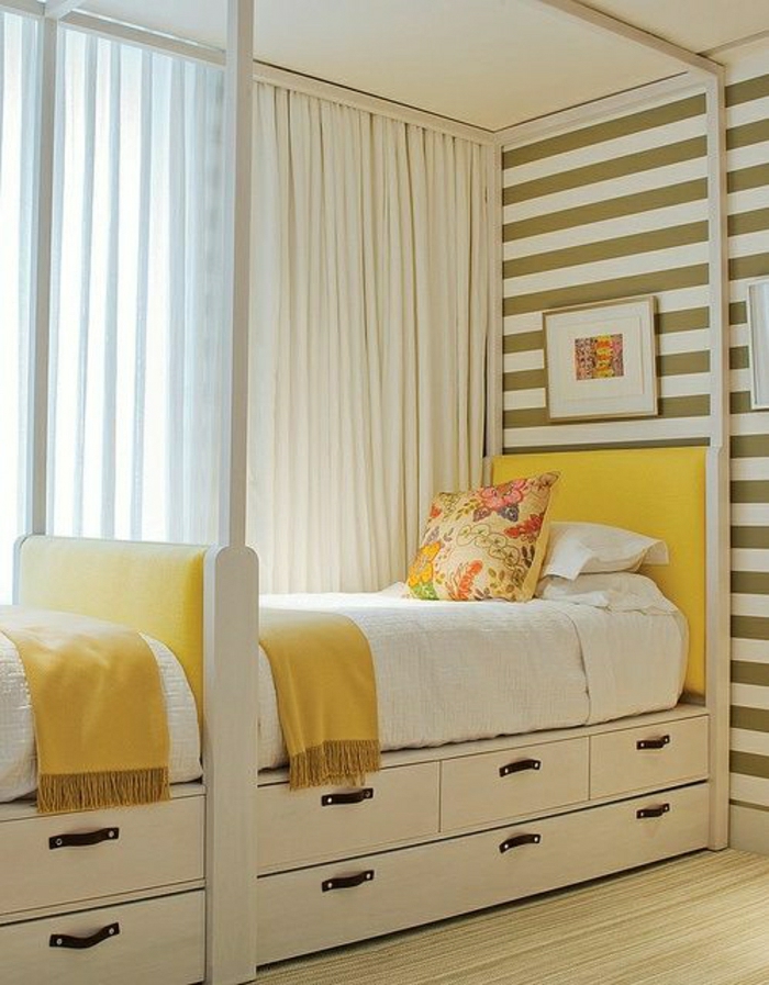 gestreifte-Wände-gelbe-Betten-Schubladen-Schlafdecken-bunte-Kisse-Bild-weiße-Gardinen