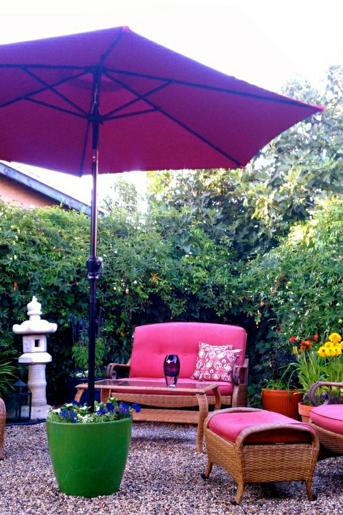 großer-lila-Gartenschirm-Blumentopf-rosige-Gartenmöbel-Rattan-dekorative-Steine