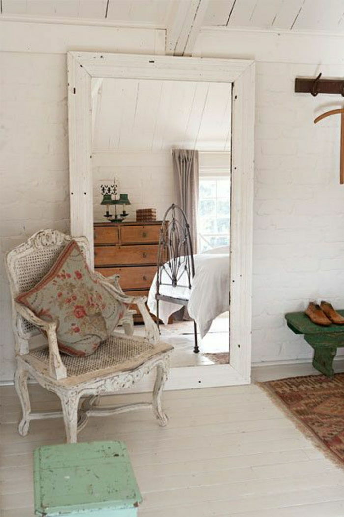 großer-weißer-vintage-Spiegel-Rahmen-Sessel-Kisse-Kasten-Bank-Teppich-weiße-Wände
