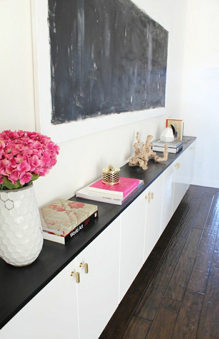 weißer-Schrank-Bücher-Souveniers-rosige-Blumen-schwarze-Tafel-Wanddeko