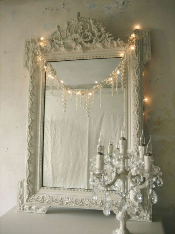 weißes-vintage-Spiegel-Rahmen-Ornamente-aristokratisch-Kette-Perlen-Leuchten-Kerzenhalter-Kristalle