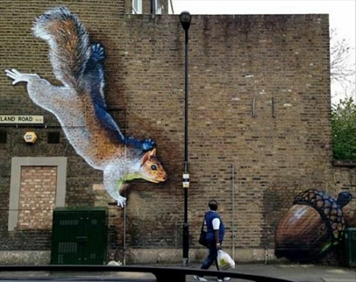 Gebäude-Ziegelwand-Graffiti-Eichhörnchen-Eichel-lustige-Zeichnung