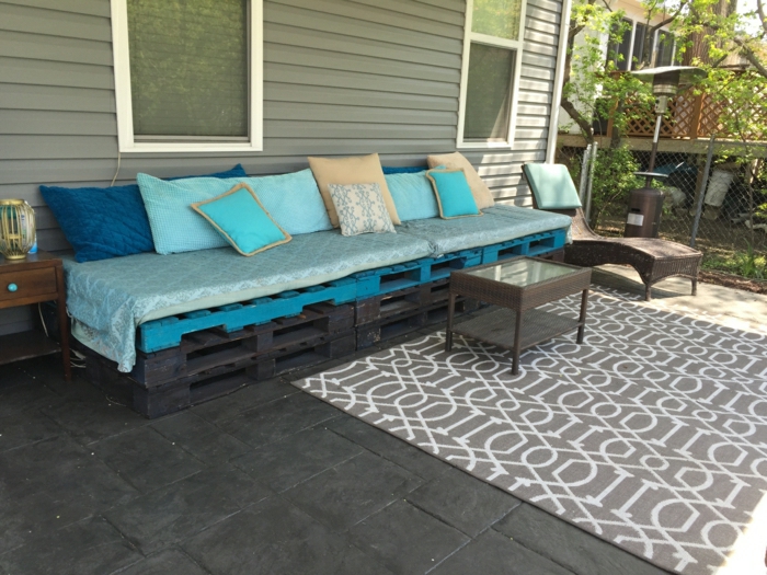 Veranda-Gestaltung-Paletten-Couch-blaue-Matrazen-Kissen-Teppich-Couchtisch-Liegestuhl-Rattan