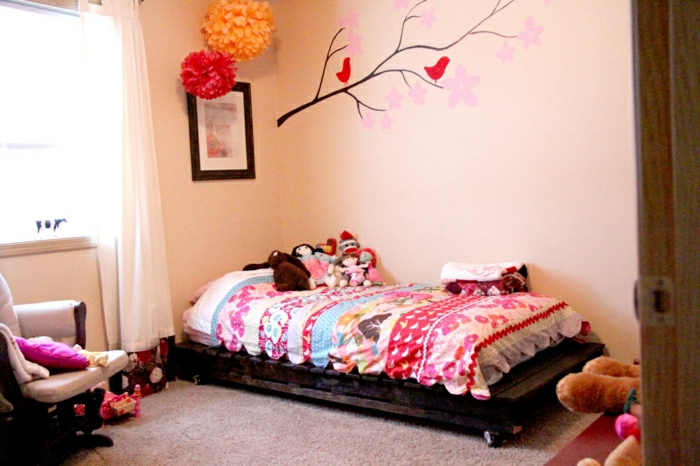 bett-selber-bauen-Paletten-Rollen-bunte-Bettwäsche-Kinderzimmer-Papierblumen-Wandtattoos-Plüschtiere-Sessel-grelle-Farben