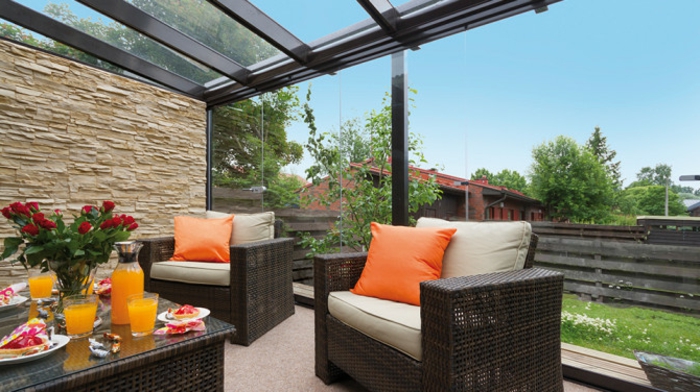 glasswand-terrasse-orange-dekokissen-auf-den-sesseln