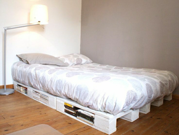 möbel-aus-paletten-weißes-Bett-Speicher-Bücher-Bettwäsche-Runden-graues-Kissen-Stehlampe-minimalistisches-Interieur
