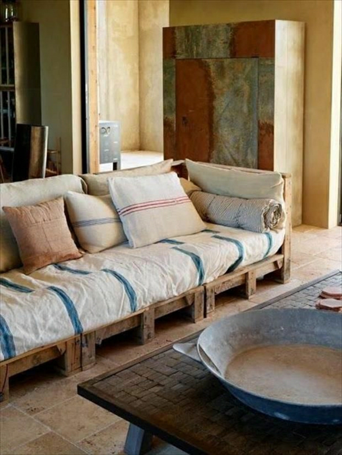 rustikales-Interieur-Sofa-aus-Paletten-Pastellfarben-Kissen-Couchtisch