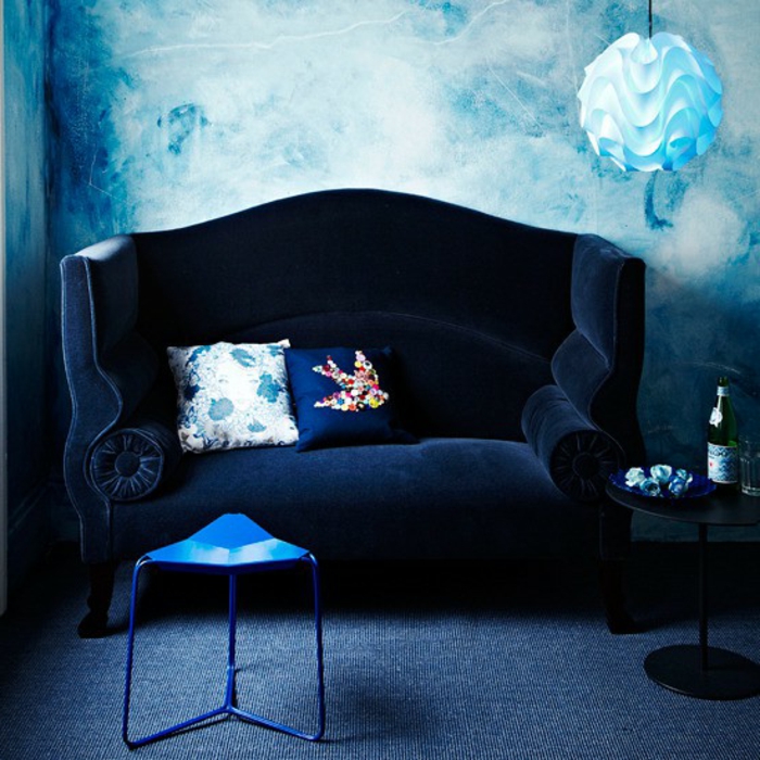 sofa-aus-samt-blaue-wand-hinter-dem-sofa