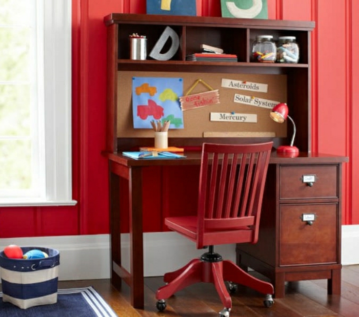 Kinderzimmer-rote-Wand-extravagante-Gestaltung-Schreibtisch-mit-Regal-roter-Stuhl-Rollen-Einweckgläser-Leselampe-blauer-Teppich