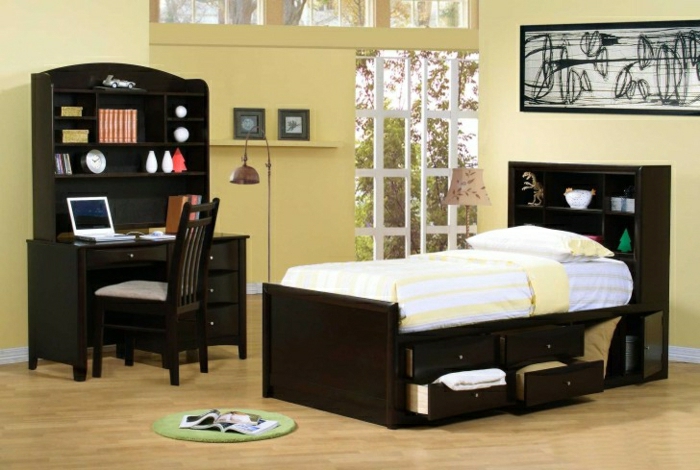 Schlafzimmer-gelbe-Wände-schwarze-Möbel-Bett-Schubladen-Schreibtisch-Regale-Laptop-Stehlampe