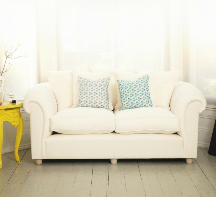 Sofa-Creme-Farbe-Polster-weich-bequem-bunte-Kissen-gelber-Tisch