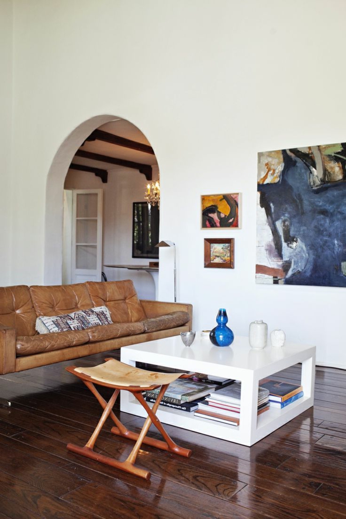Wohnzimmer-stilvolles-Interieur-Leder-Sofa-Couchtisch-weiß-Hocker