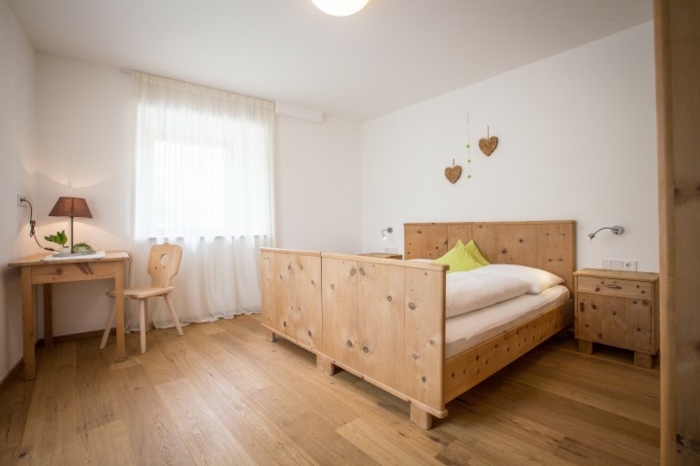 Zirbenholzmöbel-gemütliches-schlafzimmer-mit-einem-bett