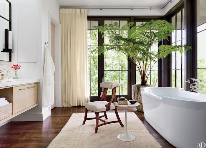 Luxus Bad Einrichtung, dunkler Holzboden, weiße Keramik Badewanne, großer Fenster, Grünpflanze in Blumentopf