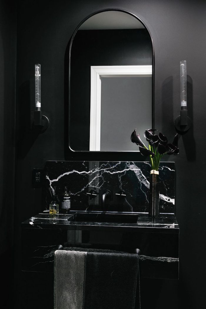 Bad Gestaltung in Schwarz, abgerundeter Spiegel und Marmor Waschbeken, zwei Wandleuchten 