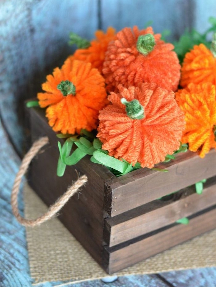 Kleine Kürbisse aus Garn selber machen, orange Bommeln, DIY Idee für herbstliche Deko 