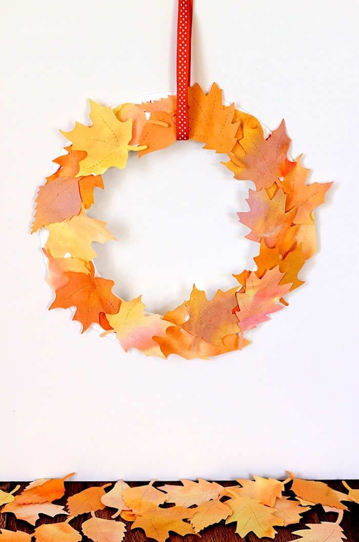 Herbstkranz selber machen mit Herbstblättern aus Papier, mit rotem Band 