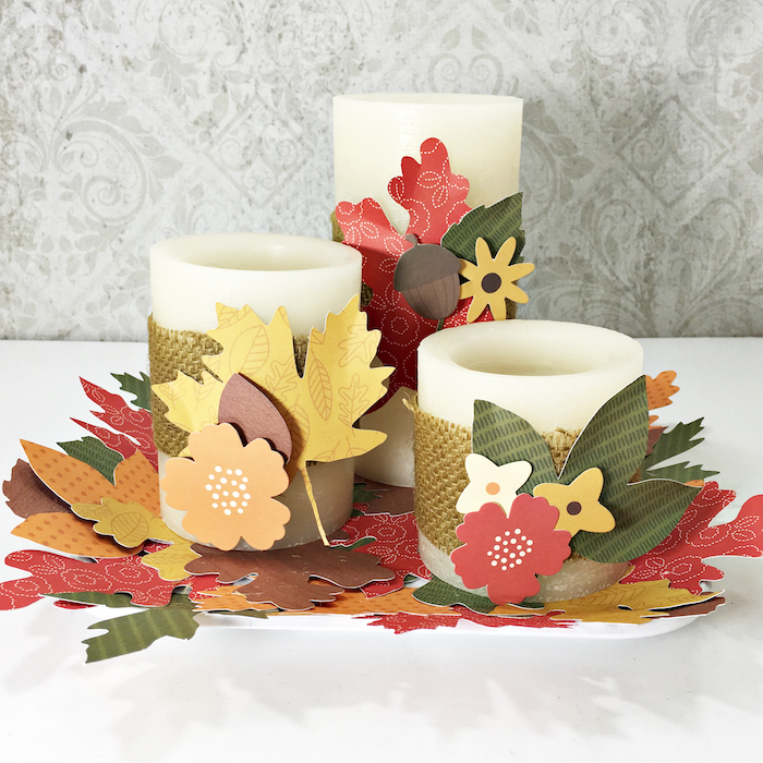 Weiße Kerzen herbstlich dekorieren, mit Herbstblättern, Eicheln und Blumen aus Papier 