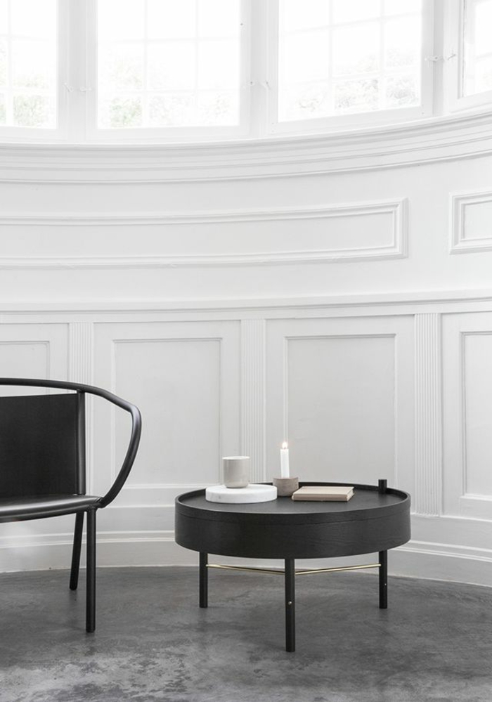 minimalistische-Gestaltung-weiße-Wände-runder-Nesttisch-Kerze-schwarze-elegante-Möbel