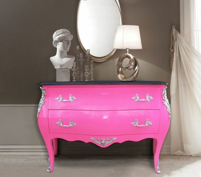 rosa-Kommode-silberne-Ornamente-schwarze-Tischplatte-Schubladen-Barock-Stil-Nachtlampe-Skulptur-Spiegel-gläserne-Kerzenhalter-weiße-Gardinen