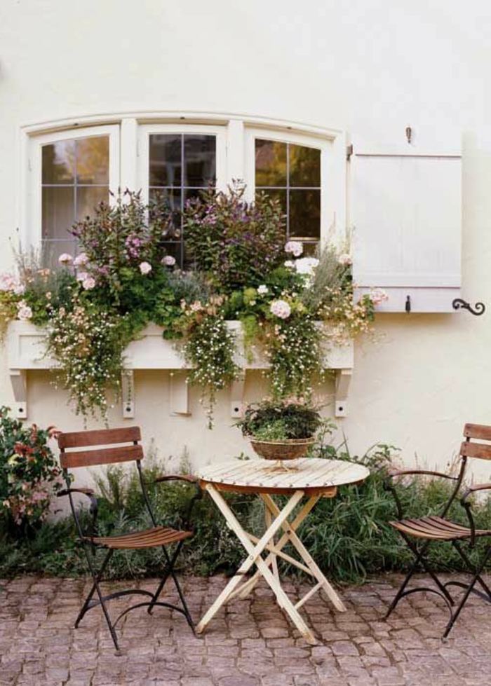 Garten-Tisch-Stühle-Schmiedeeisen-viele-Blumentöpfe-Fensterladen-Holz-weiß