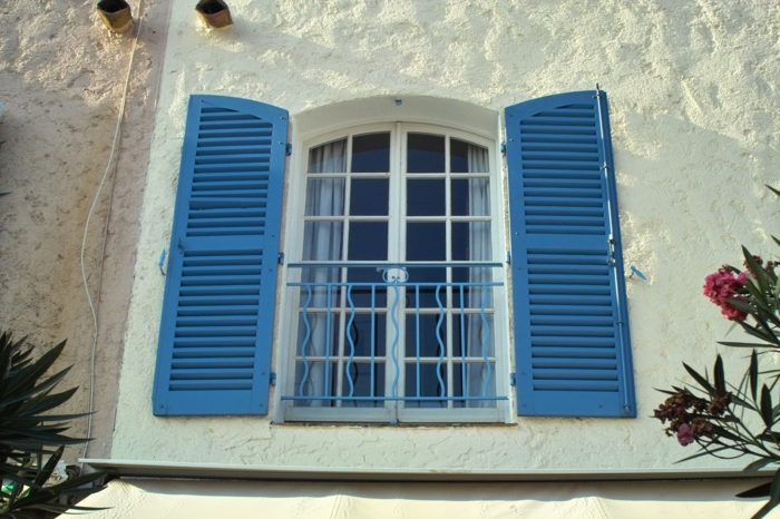 Haus-mediterraner-Stil-Fenster-exotische-Blumen-blaue-Fensterläden
