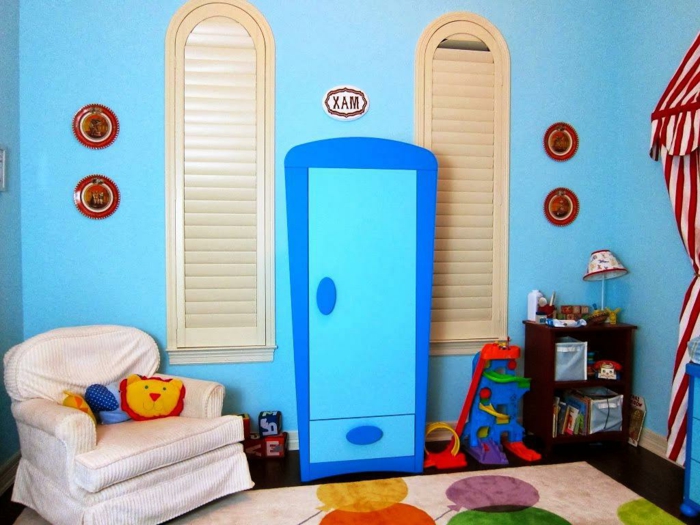 Kinderzimmer-blaue-Wände-Sessel-Spielzeuge-attraktiver-blauer-Kleiderschrank