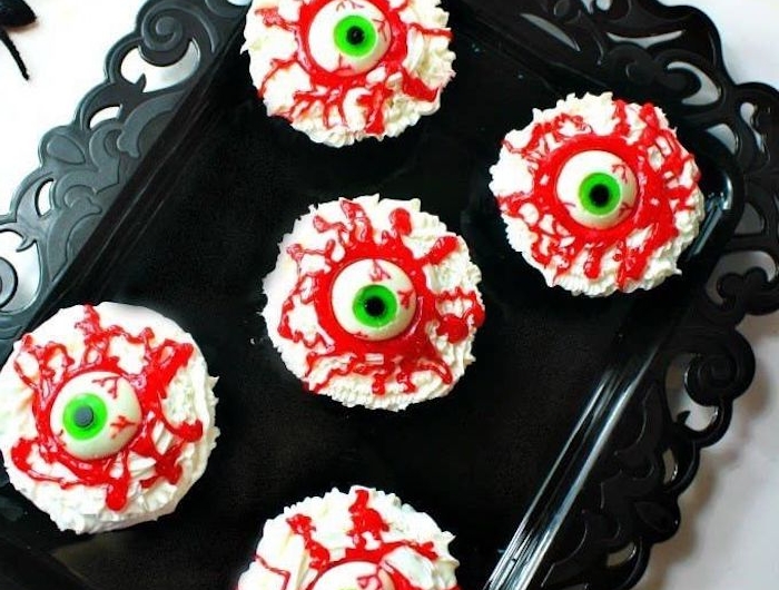 augenapfel cupcakes halloween snack ideen weißer zuckerguss dekoration schwarze spinnen grüne augen ausgefallen backideen lustige muffins