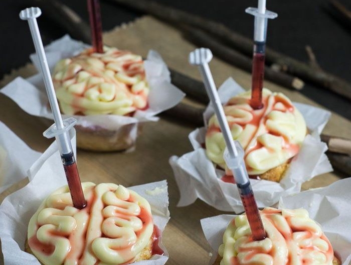 cupcakes weißer zuckerguss gehirn form eingestochene spritzen mit blut halloween backen ausgefallene ideen