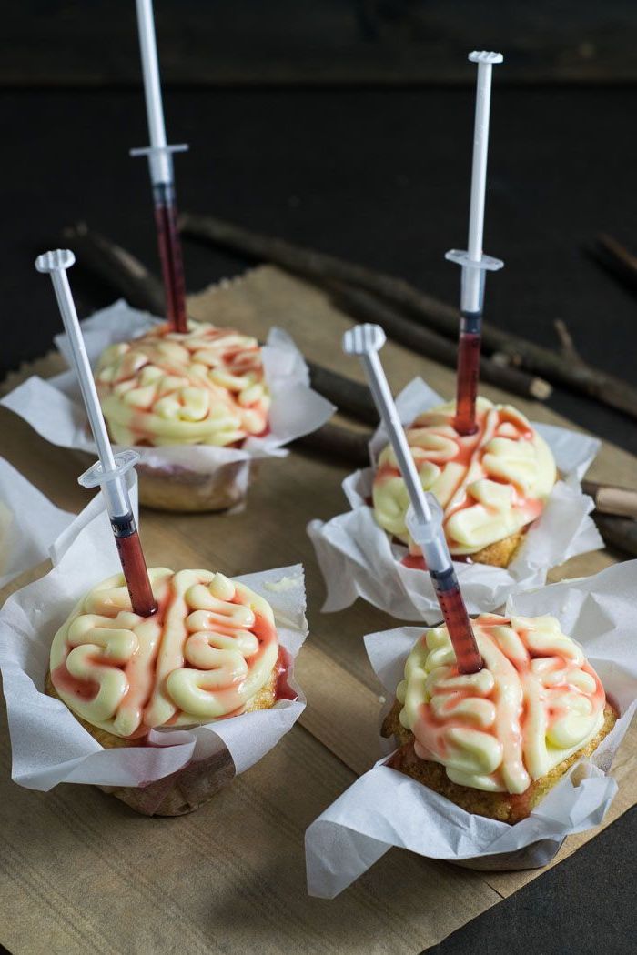 cupcakes weißer zuckerguss gehirn form eingestochene spritzen mit blut halloween backen ausgefallene ideen