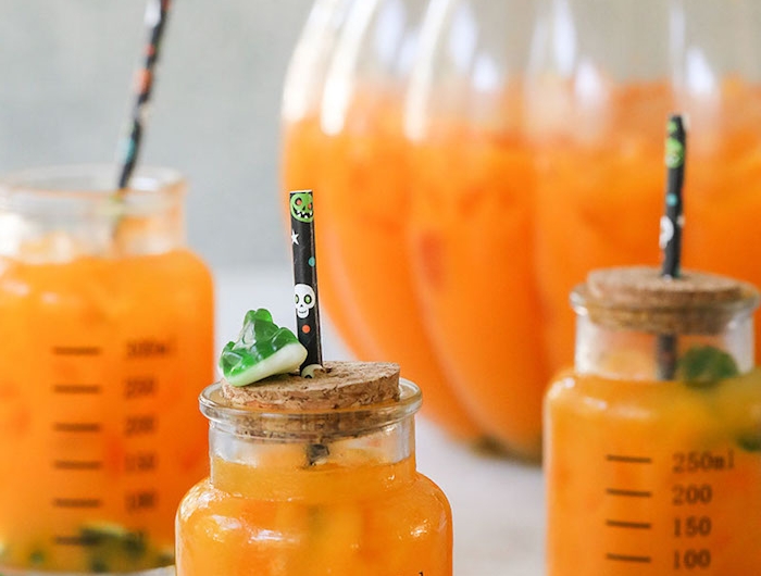 kinder punch halloween rezepte cocktail alkoholfrei kinderparty punch mit orangensaft gummifrösche gummiwürmer schwarzer strohhalm mit schädeln