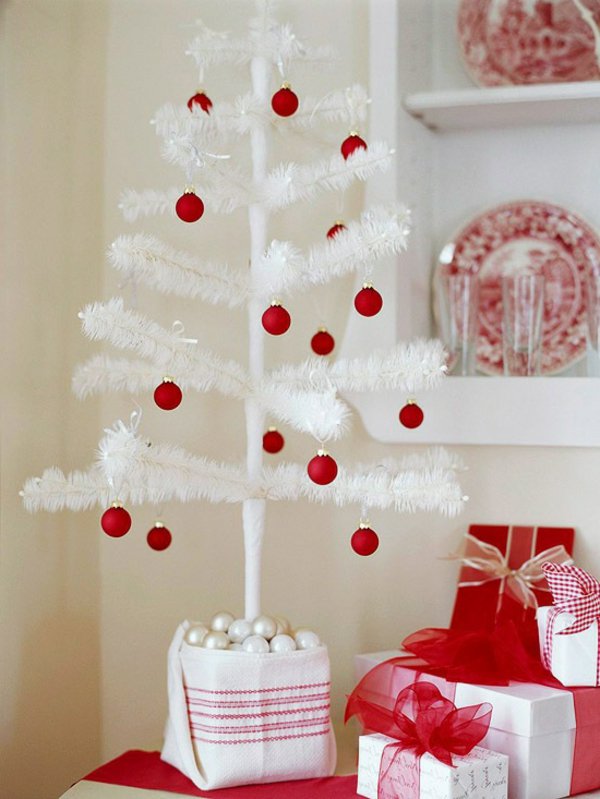 kleiner-dekorativer-weisser-Tannenbaum-rote-Kugeln-Dekoration-Geschenke