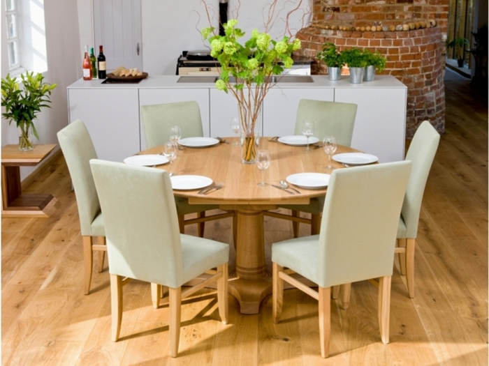 runder-Esstisch-Holz-beige-Stühle-Tischdekoration-Teller-Gläser-gemütliches-Interieur