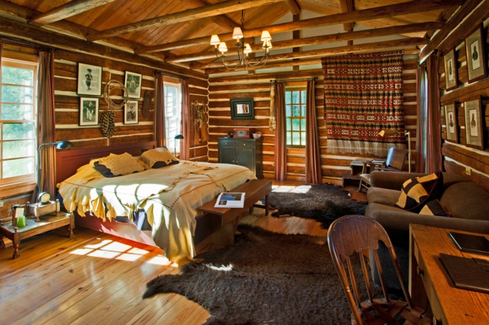 rustikales-Schlafzimmer-Holz-moderne-Landhausmöbel-großes-Bett-Pelz-bequemes-braunes-Sofa