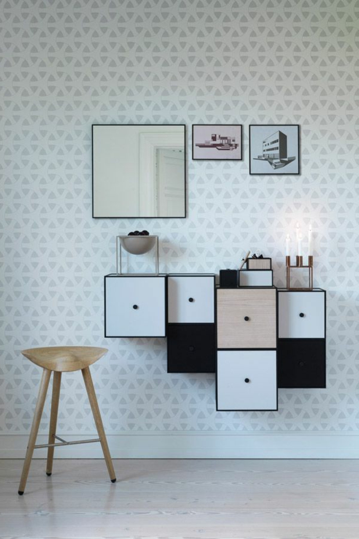 skandinavisches-Interieur-minimalistisch-weiße-Tapeten-graue-geometrische-Ornamente-rustikaler-Hocker-asymetrische-Regale