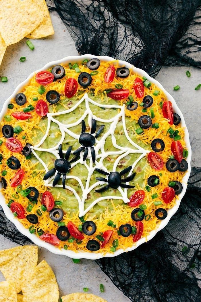 vorspeisen ideen spinnennetz avocado dip mit käse tomaten schwarze oliven dekoration schwarze spinnen halloween buffet