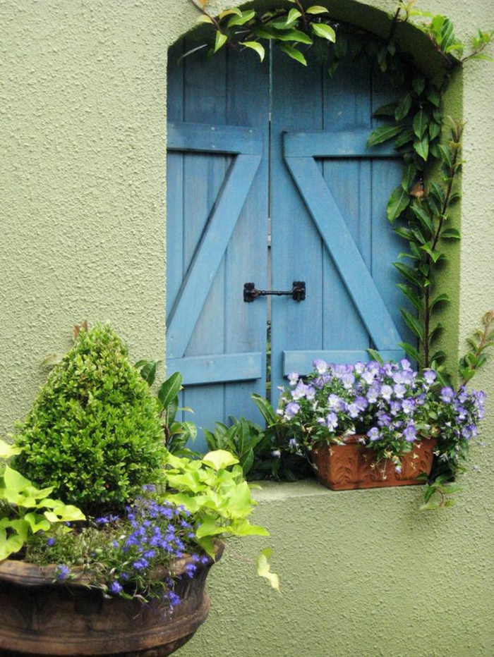 wunderschöne-blaue-Fensterläden-Blumen-grüne-Wand