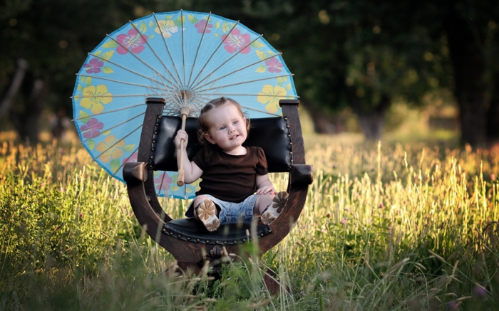 Baby-Mädchen-Sessel-im-Gras-kokettes-Modell-Kinderschirm