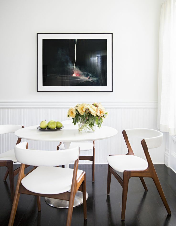Esszimmer-weiße-Wände-runder-Tisch-Blumen-Birnen-Tischdekoration-Designer-Stühle-Sessel