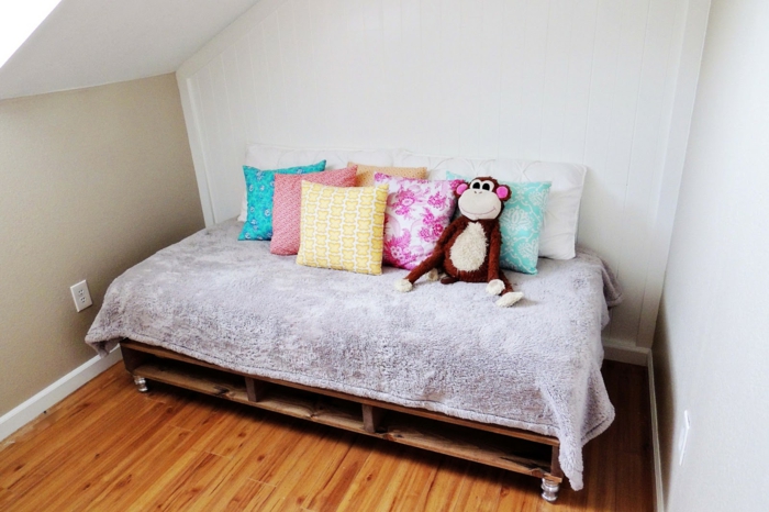 Kinderzimmer-möbel-aus-paletten-Europaletten-Bett-Rollen-viele-Kissen-Plüschtier-Affe