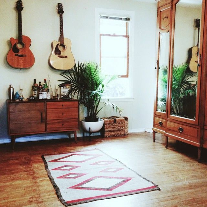 Raum-vintage-Möbel-Topfpflanze-kleiner-vintage-Teppich-akustische-Gitarren-an-der-Wand