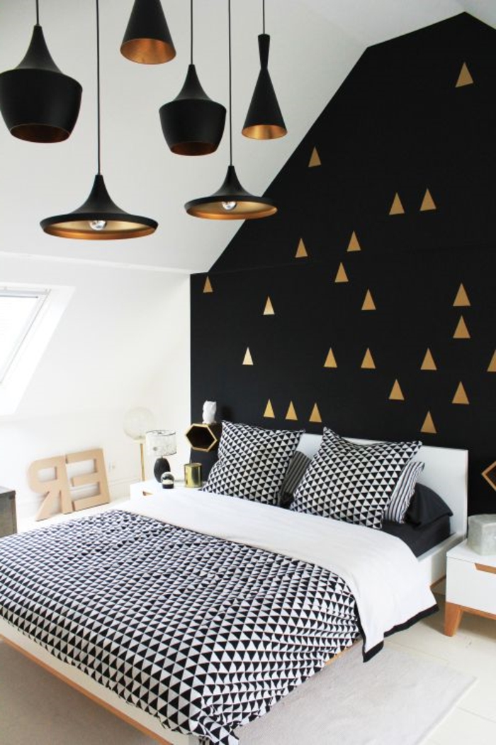 Schlafzimmer-schwarz-weißes-Interieur-Dreiecken-Motive-goldene-Elemente-schwarze-Designer-Leuchten